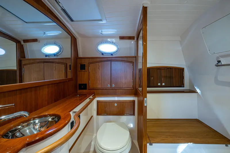  Yacht Photos Pics Luxurious 2025 Hinckley Picnic Boat 40 bathroom with wooden cabinetry and modern fixtures.