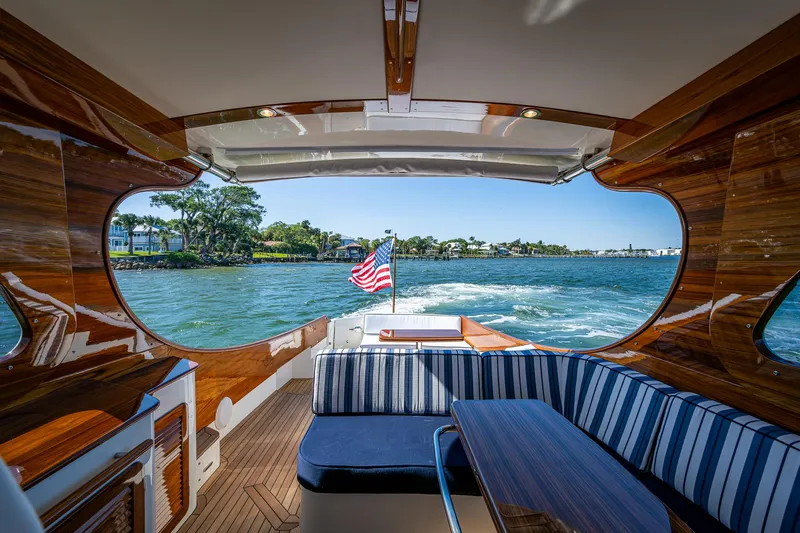  Yacht Photos Pics 2025 Hinckley Picnic Boat 40 interior with striped seating, wooden finish, and ocean view.