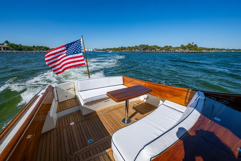  Yacht Photos Pics 2025 Hinckley Picnic Boat 40 cruising with American flag, featuring elegant deck seating.
