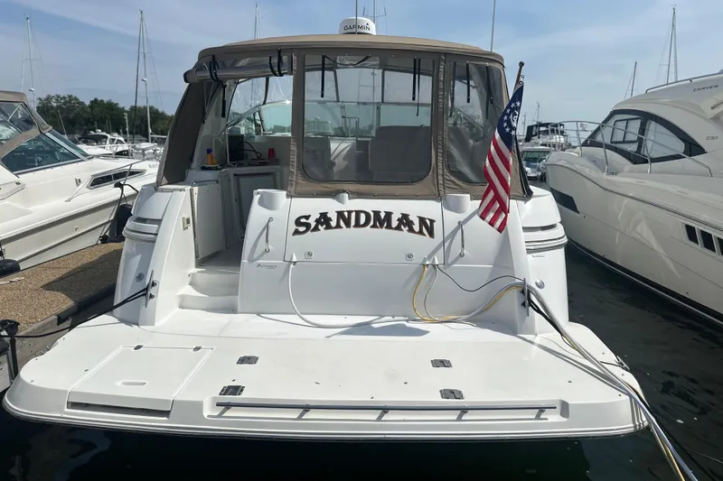 Sandman Yacht Photos Pics 2001 Cruisers Yachts 3870 Express docked, featuring "Sandman" name and American flag.