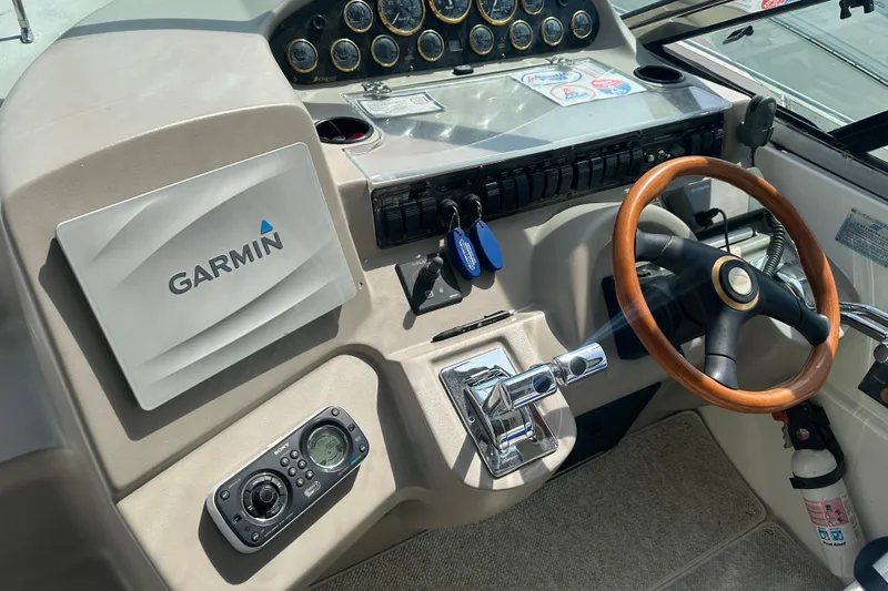 Sandman Yacht Photos Pics 2001 Cruisers Yachts 3870 Express helm with Garmin navigation and wooden steering wheel.
