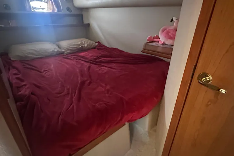Sandman Yacht Photos Pics Cozy bedroom in 2001 Cruisers Yachts 3870 Express with red bedding and plush decor.