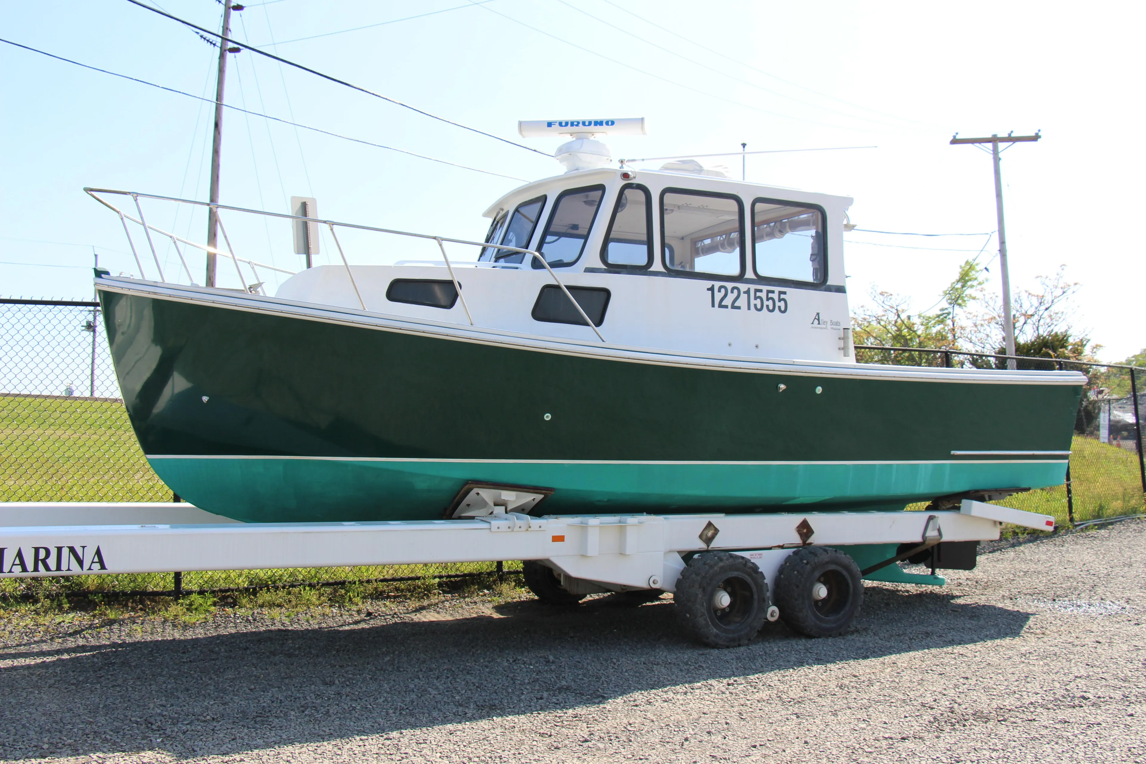 2009 Custom Alley Boats 28 Downeast on trailer, green hull, docked at marina.
