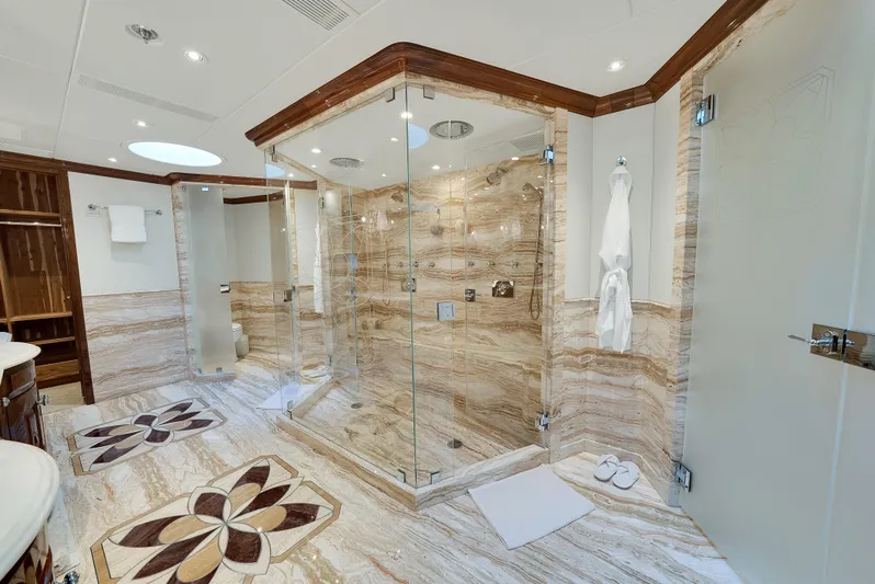 Silver Lining Yacht Photos Pics Luxurious bathroom on 2016 Christensen Tri-Deck yacht with glass shower and elegant marble design.