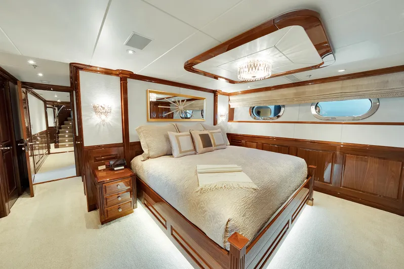 Silver Lining Yacht Photos Pics Luxurious bedroom on 2016 Christensen Tri-Deck yacht with elegant wood paneling and plush bedding.