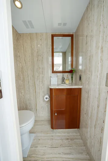 Silver Lining Yacht Photos Pics Luxurious bathroom on 2016 Christensen Tri-Deck yacht with elegant wood cabinetry and marble walls.