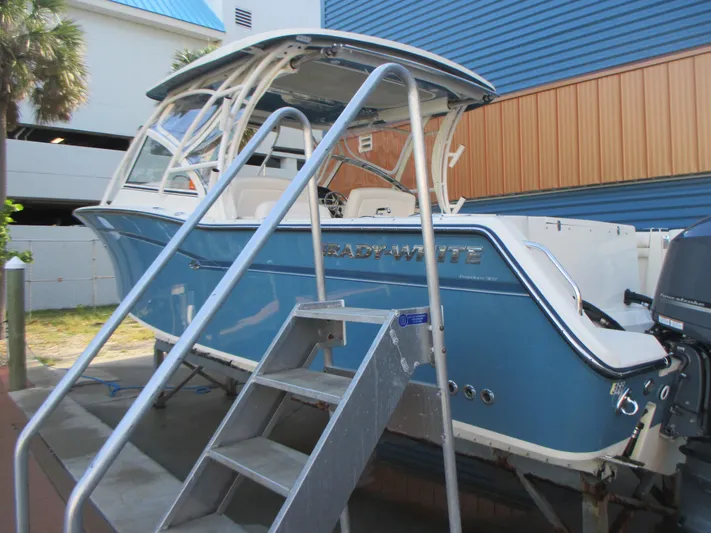  Yacht Photos Pics 2018 Grady-White Freedom 307 boat in blue, docked with metal stairs.