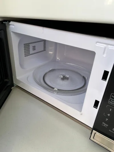  Yacht Photos Pics Open microwave oven with a clean interior and glass turntable.
