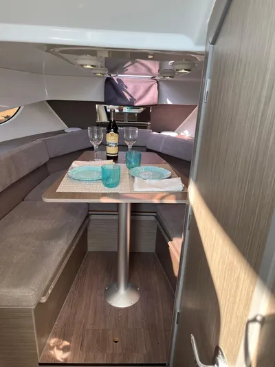  Yacht Photos Pics 2024 Beneteau 29' Flyer 9 SUNdeck interior with dining setup, featuring wine and tableware.