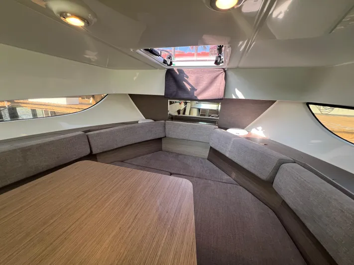  Yacht Photos Pics 2024 Beneteau Flyer 9 SUNdeck interior with cozy seating and wooden table.