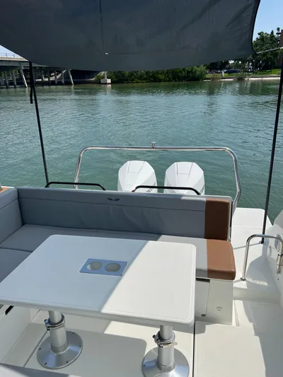  Yacht Photos Pics 2024 Beneteau 29' Flyer 9 SUNdeck, rear seating area with table, overlooking calm waters.