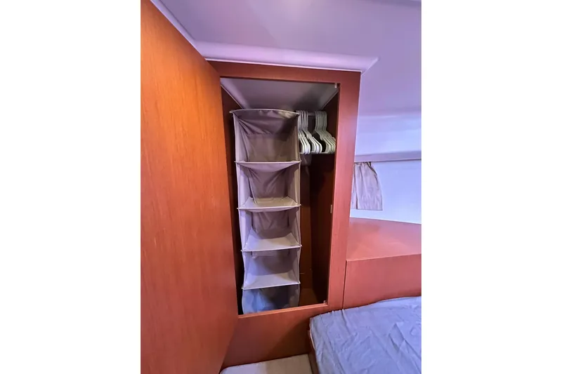 Dark Star Yacht Photos Pics Interior storage of 2016 Beneteau Swift Trawler 34 with hanging shelves and wooden finish.