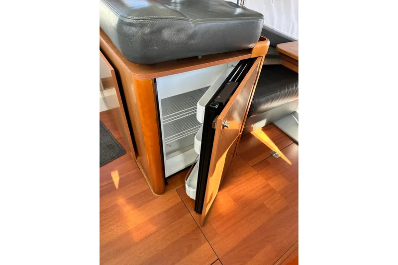 Dark Star Yacht Photos Pics 2016 Beneteau Swift Trawler 34 interior with open mini fridge and wooden flooring.