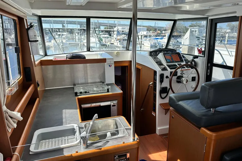 Dark Star Yacht Photos Pics 2016 Beneteau Swift Trawler 34 interior with helm, kitchen, and marina view.