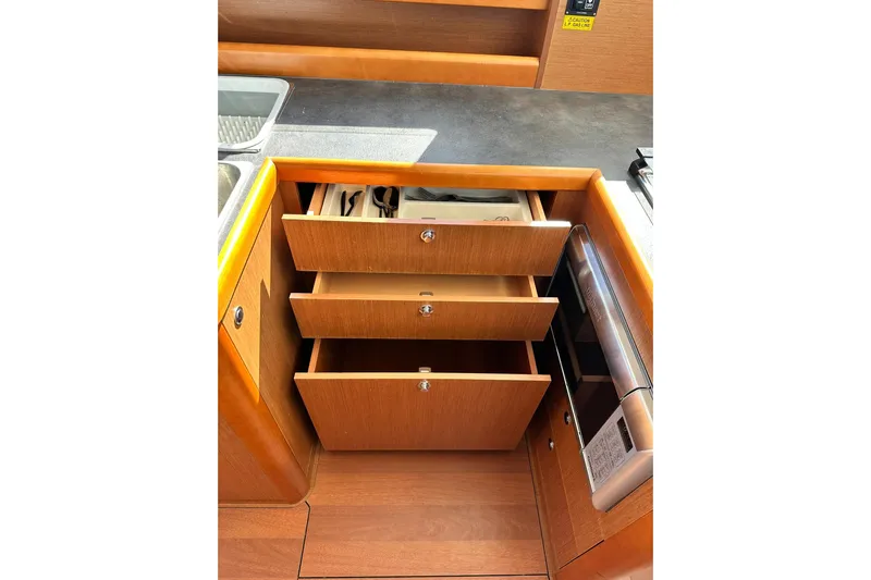 Dark Star Yacht Photos Pics 2016 Beneteau Swift Trawler 34 kitchen with open wooden drawers and modern appliances.