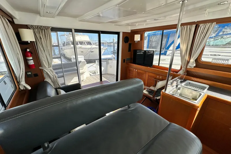 Dark Star Yacht Photos Pics Interior of 2016 Beneteau Swift Trawler 34, featuring seating, sink, and marina view.