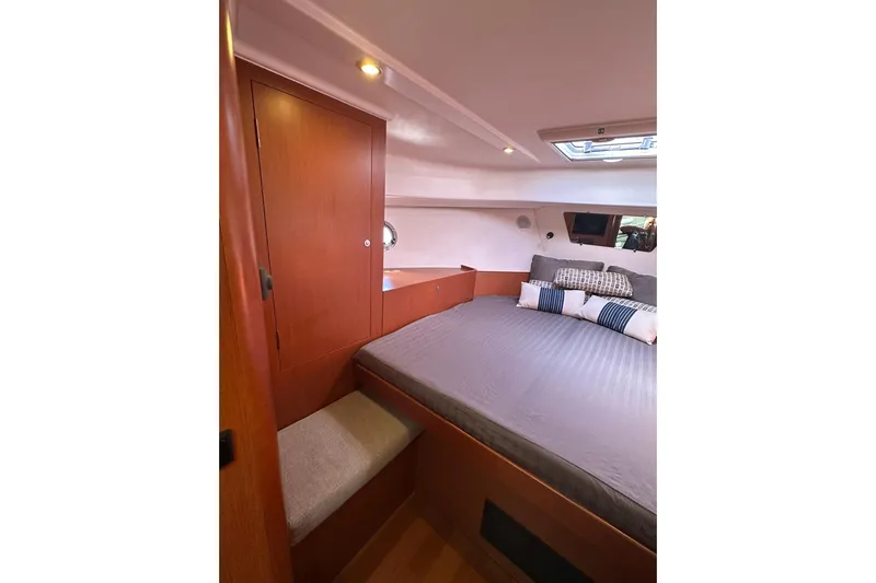Dark Star Yacht Photos Pics 2016 Beneteau Swift Trawler 34 cabin interior with bed, wooden cabinetry, and skylight.