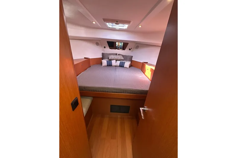 Dark Star Yacht Photos Pics 2016 Beneteau Swift Trawler 34 cabin interior with cozy bed and wooden finish.