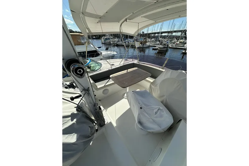 Dark Star Yacht Photos Pics 2016 Beneteau Swift Trawler 34 deck with table, marina view in background.