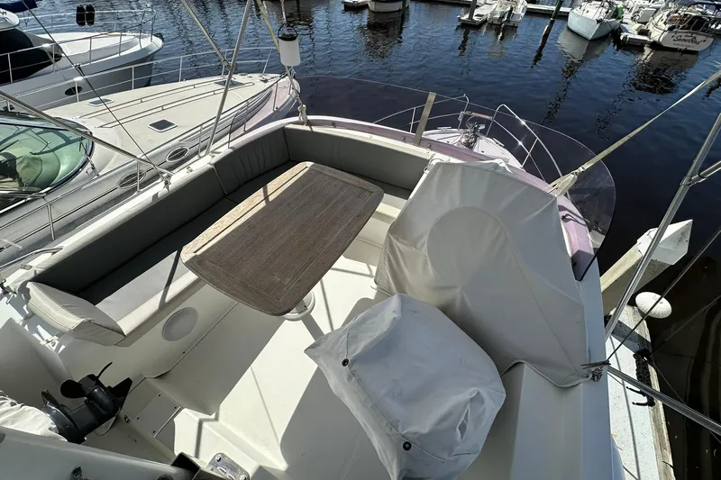 Dark Star Yacht Photos Pics 2016 Beneteau Swift Trawler 34 flybridge with seating and table, docked at marina.