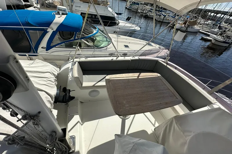 Dark Star Yacht Photos Pics 2016 Beneteau Swift Trawler 34 flybridge with seating and table, docked at marina.