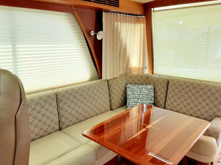 Happy Days Yacht Photos Pics Interior of 2016 Sabre 48 Salon Express with elegant seating and wooden table.