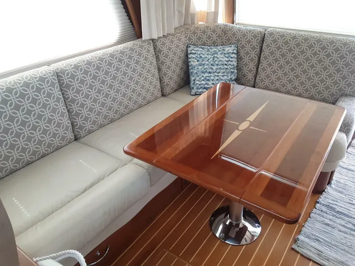 Happy Days Yacht Photos Pics 2016 Sabre 48 Salon Express interior with patterned seating and polished wooden table.