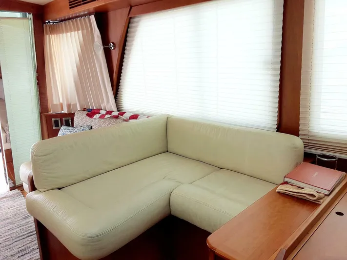 Happy Days Yacht Photos Pics Interior of 2016 Sabre 48 Salon Express with cream L-shaped sofa and wooden accents.