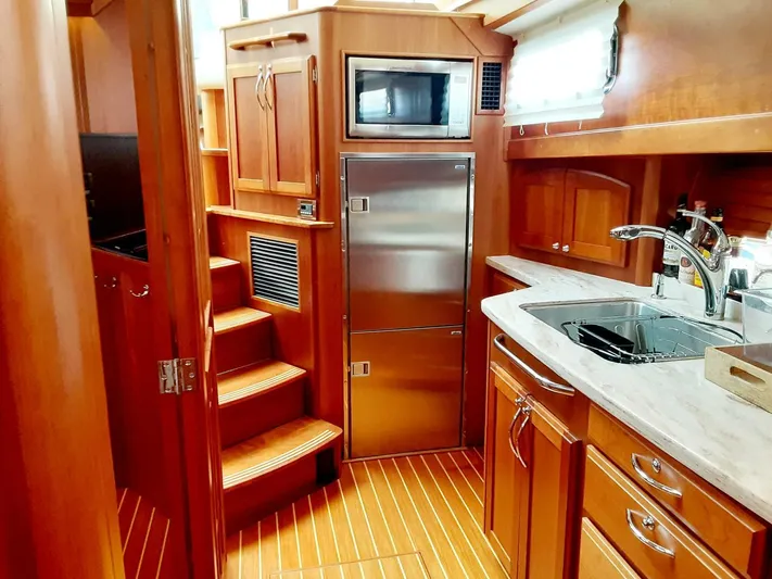 Happy Days Yacht Photos Pics Interior of 2016 Sabre 48 Salon Express yacht with wooden cabinetry and modern kitchen amenities.