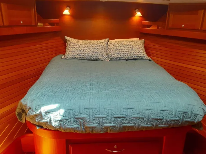 Happy Days Yacht Photos Pics Cozy bedroom in 2016 Sabre 48 Salon Express yacht with wooden paneling and blue bedding.
