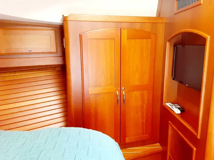 Happy Days Yacht Photos Pics Interior of 2016 Sabre 48 Salon Express with wooden cabinetry and mounted TV.