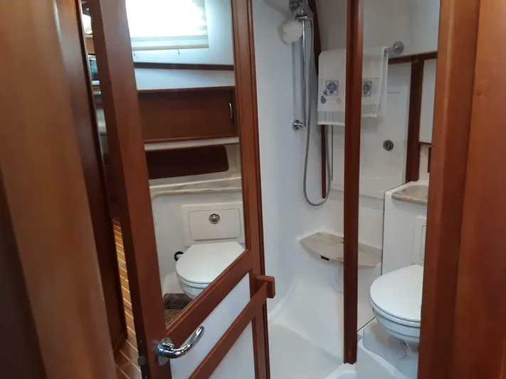 Happy Days Yacht Photos Pics 2016 Sabre 48 Salon Express bathroom with shower, toilet, and wooden cabinetry.