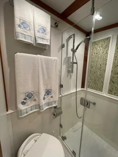 Happy Days Yacht Photos Pics Bathroom in 2016 Sabre 48 Salon Express with glass shower and nautical-themed towels.