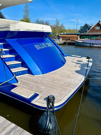  Yacht Photos Pics Van der Heijden Phantom 70 Fly yacht, 2021 model, docked with wooden deck and blue hull.