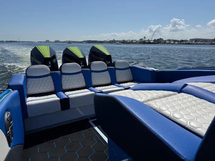 Riptide Yacht Photos Pics 2023 Statement 380 Open boat interior with blue and white seating on the water.