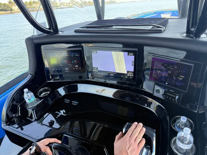 Riptide Yacht Photos Pics Control panel of 2023 Statement 380 Open boat with navigation screens and steering wheel.