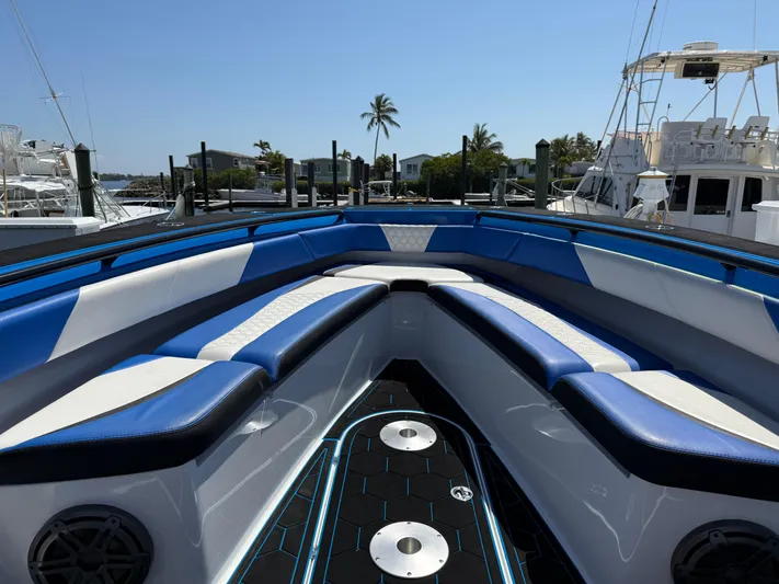 Riptide Yacht Photos Pics 2023 Statement 380 Open boat interior with blue and white seating, docked at marina.
