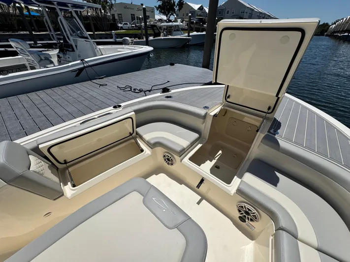  Yacht Photos Pics 2025 Scout 281 XSS boat with open storage compartments, docked by the water.