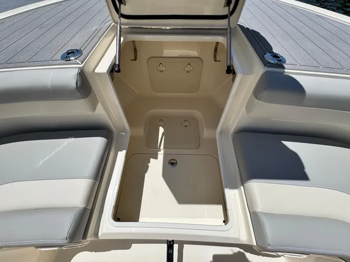  Yacht Photos Pics 2025 Scout 281 XSS boat interior with open storage compartment and cushioned seating.