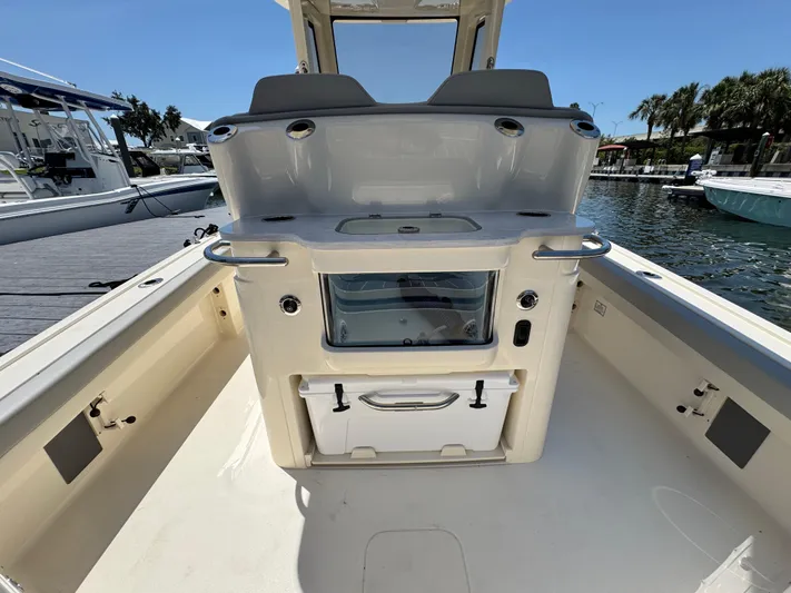  Yacht Photos Pics 2025 Scout 281 XSS boat interior with seating and storage, docked by the water.