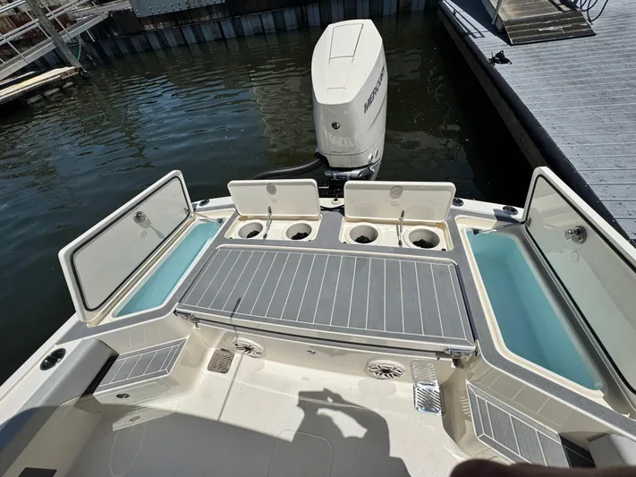  Yacht Photos Pics 2025 Scout 281 XSS boat stern view with motor and seating area.