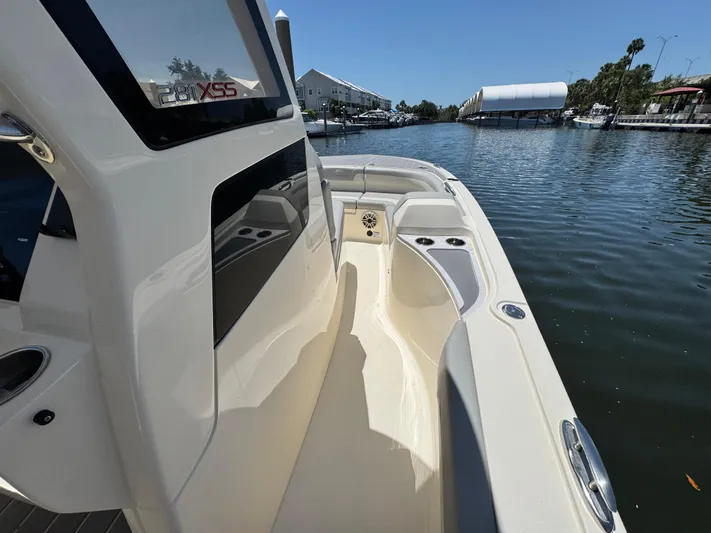  Yacht Photos Pics 2025 Scout 281 XSS boat on a calm waterway, showcasing sleek design and spacious deck.