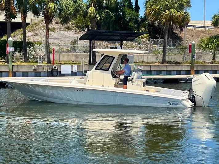  Yacht Photos Pics 2025 Scout 281 XSS boat cruising on a sunny day near palm trees.