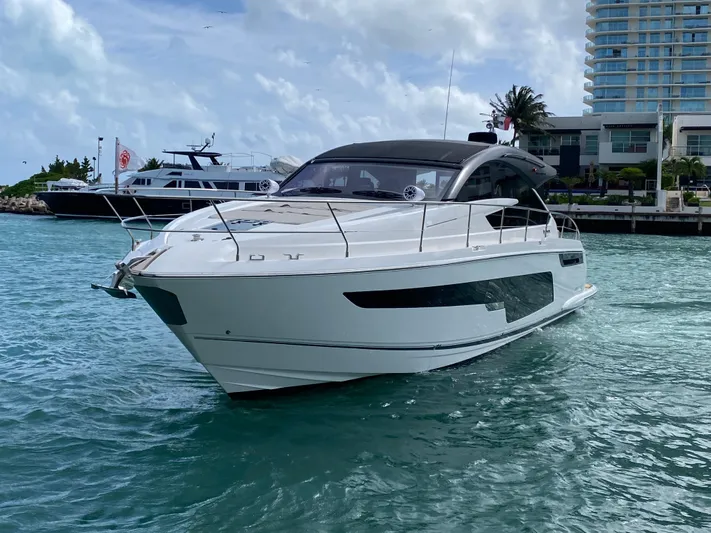 2022 Fairline Targa 50 Gt Yacht Photos Pics 2022 Fairline Targa 50 GT yacht cruising in a marina with modern buildings.