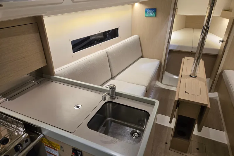 Mahalo Yacht Photos Pics Interior of 2021 Beneteau Oceanis 30.1 yacht with modern kitchen and cozy seating area.