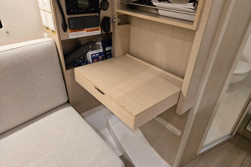 Mahalo Yacht Photos Pics Interior of 2021 Beneteau Oceanis 30.1 yacht with foldable desk and seating area.