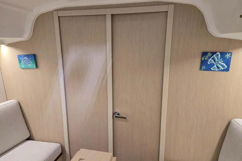 Mahalo Yacht Photos Pics Interior of 2021 Beneteau Oceanis 30.1 yacht with light wood paneling and decorative art.