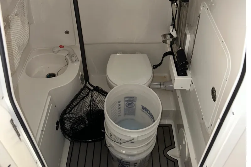  Yacht Photos Pics 2022 Sea Hunt Gamefish 30 Coffin Box interior with toilet, sink, and fishing gear.