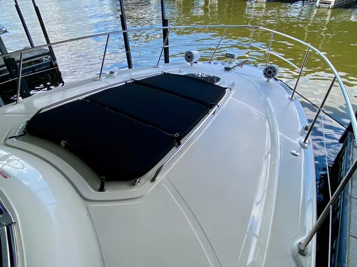  Yacht Photos Pics 2008 Sea Ray 38 Sundancer yacht bow with sunpad, docked on calm water.
