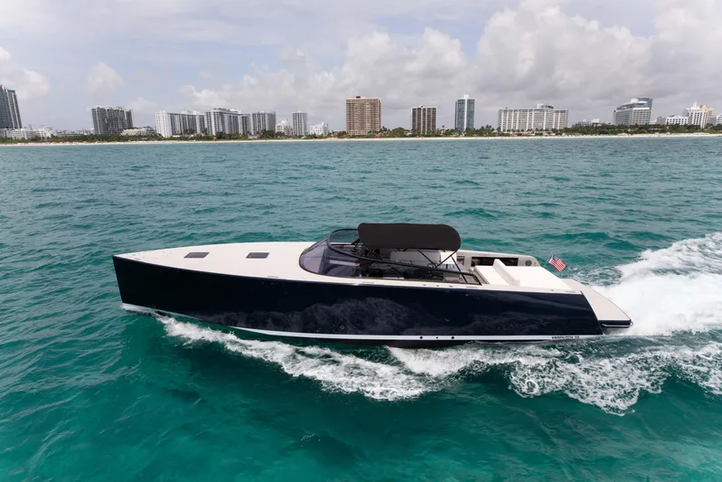 M/y 55 Van Dutch Yacht Photos Pics 2017 VanDutch 55 yacht cruising on turquoise waters near a city skyline.